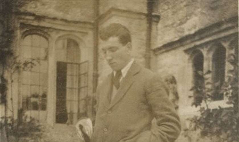Image shows a black-and-white photo of Robert Graves, where he's outside a manor house and looking down at his feet.